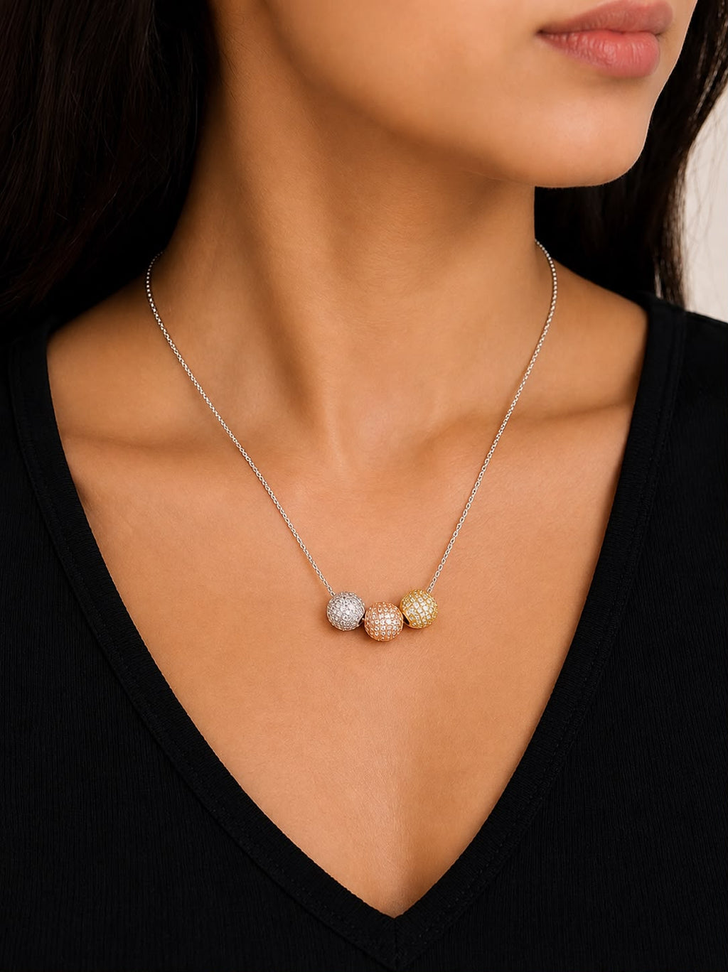 Tri-tone pavé ball necklace on navy blue fabric