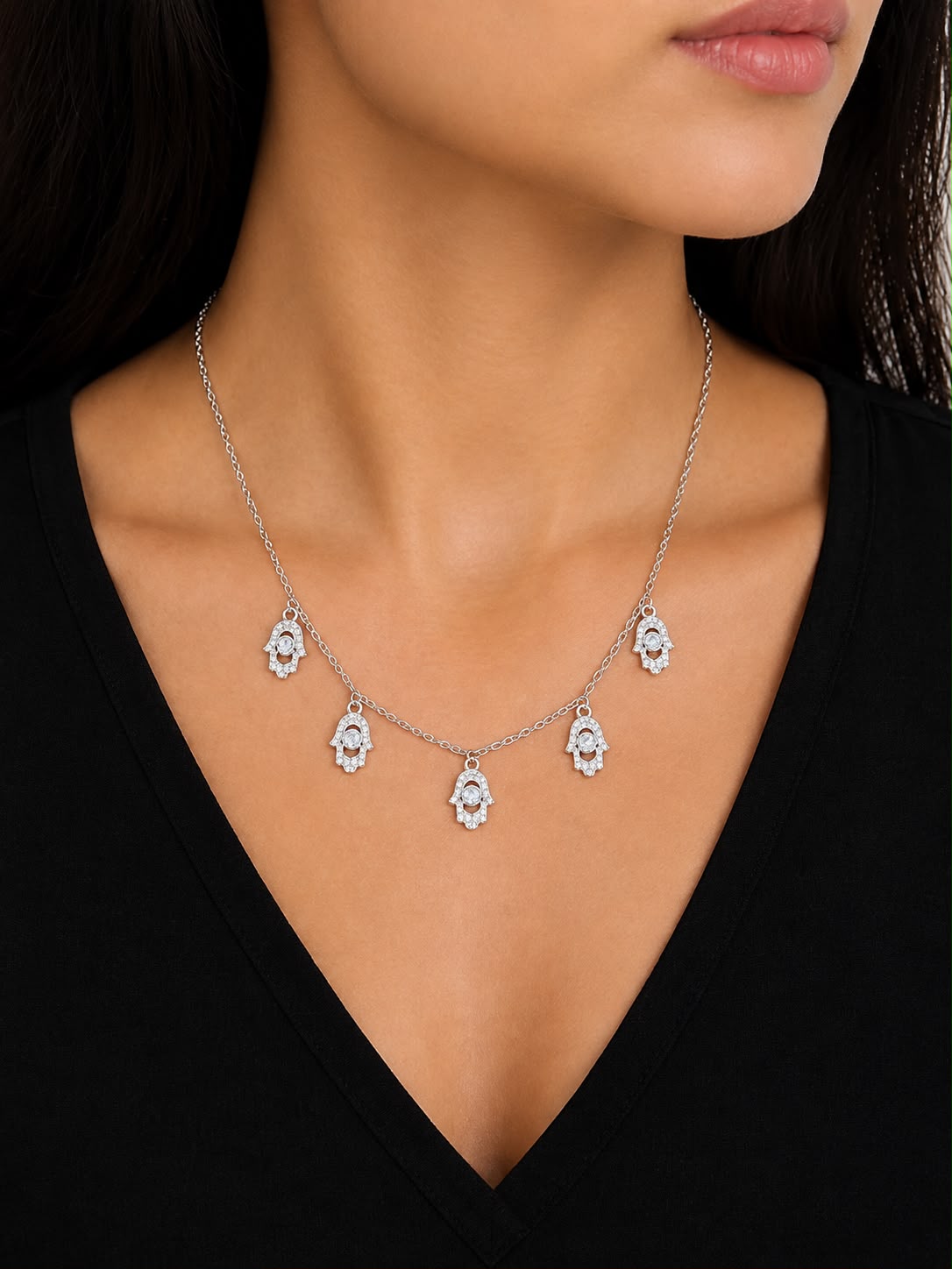 Model wearing five hamsa charm necklace on black top