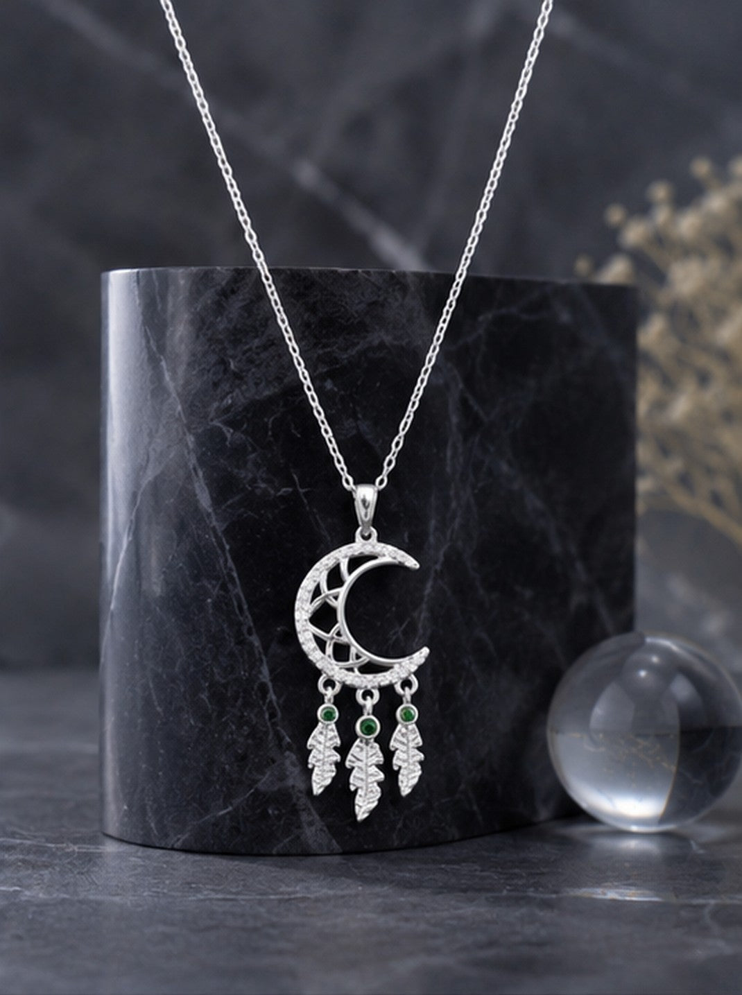 Crescent moon dreamcatcher necklace on black marble with crystal ball