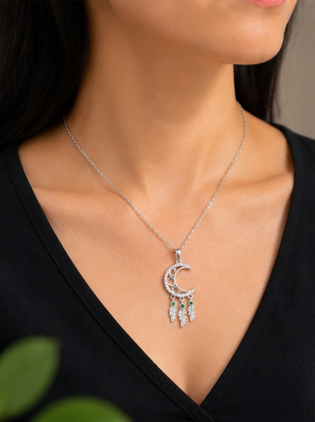 Model wearing crescent moon dreamcatcher necklace on black top