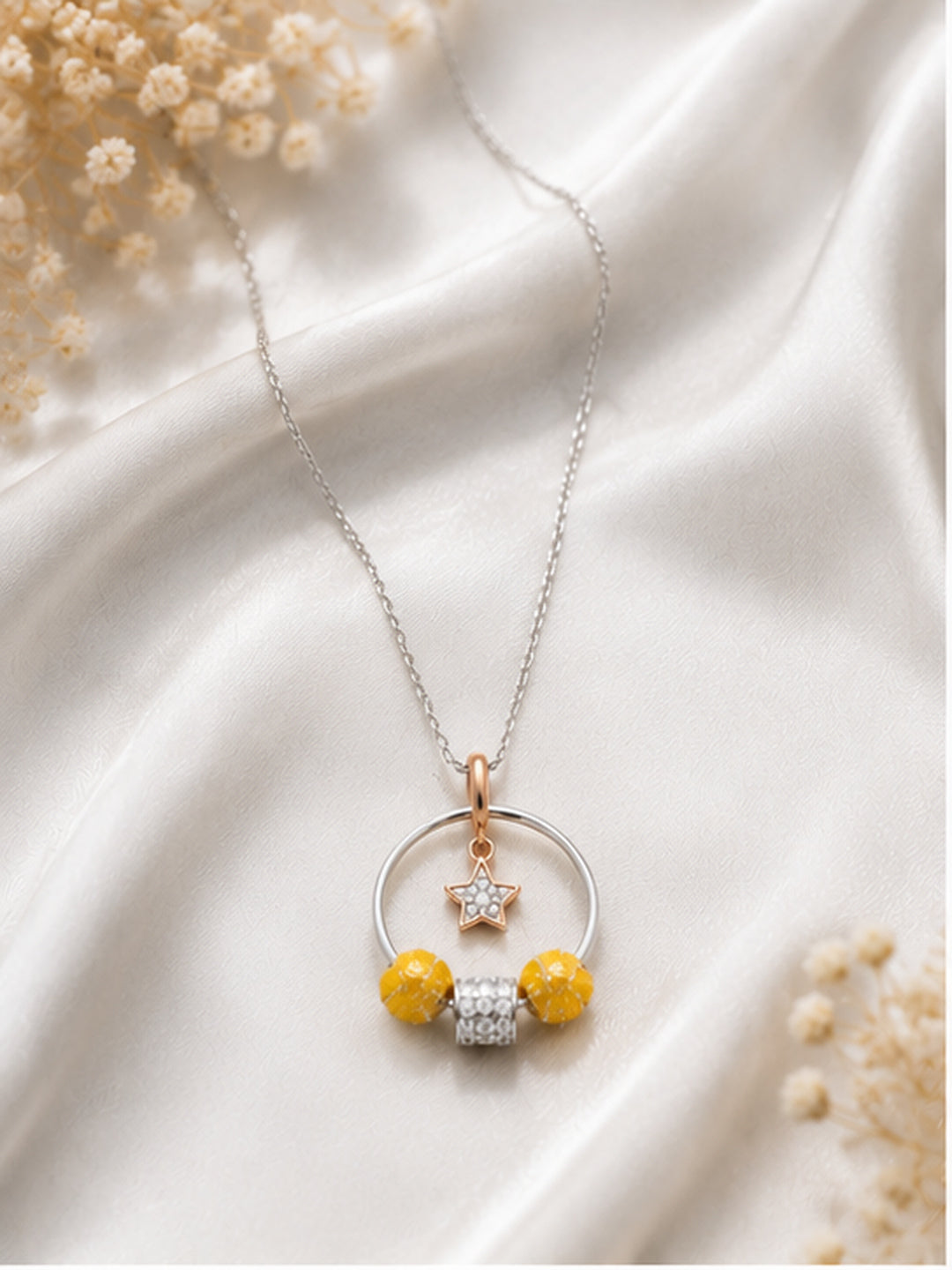 Celestial hoop star charm necklace on white satin with dried flowers